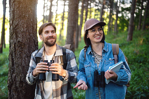 istock Two young people enjoying birdwatching in a forest setting together 2214992395