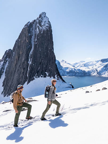 istock Two sporty people snowshoeing uphill 2214992429