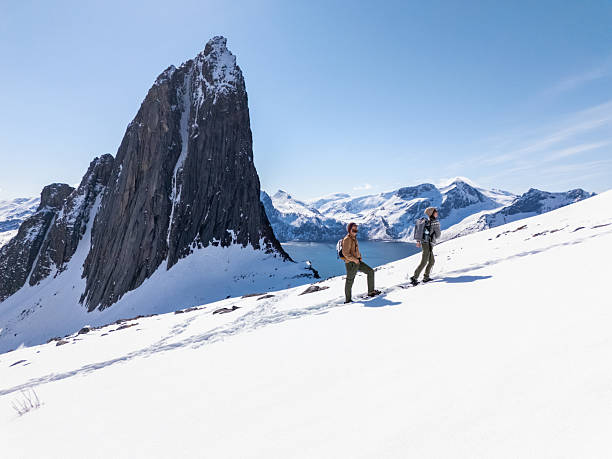 istock Two sporty people snowshoeing uphill 2214992452