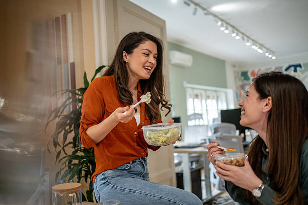 istock Two female colleagues enjoying lunch break together in office 2214993342
