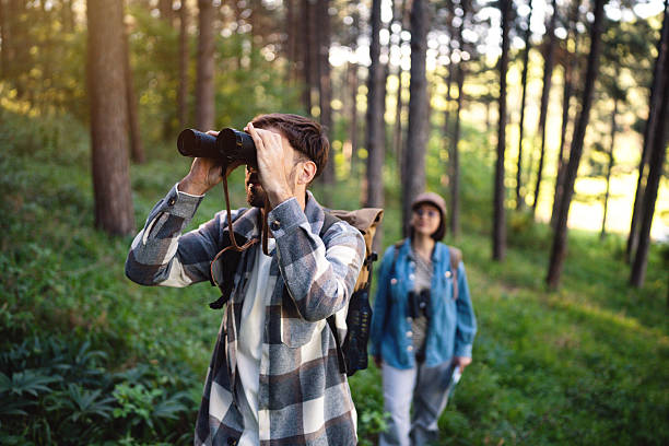 istock Two people birdwatching in a forest during a sunny day 2214993669