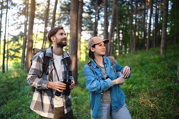 istock Young couple birdwatching in a forest during a sunny hiking excursion 2214993715