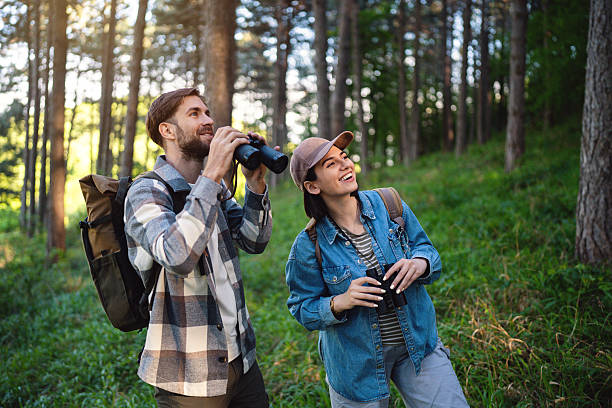 istock Young couple birdwatching in a serene forest setting on a sunny day 2214993756