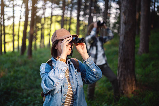 istock Young adults birdwatching together in a forested area with binoculars 2214994356