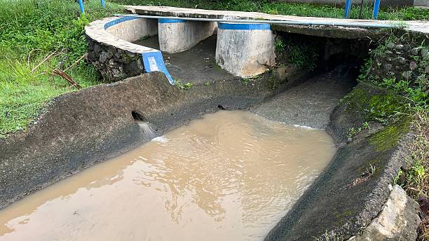 istock Rural Concrete Irrigation Canal with Murky Water Flow 2214994637
