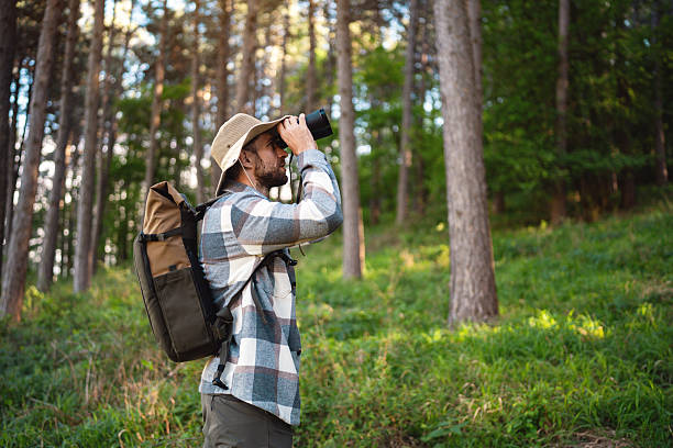 istock Nature enthusiast exploring the wilderness with binoculars and backpack in pine forest 2214994693
