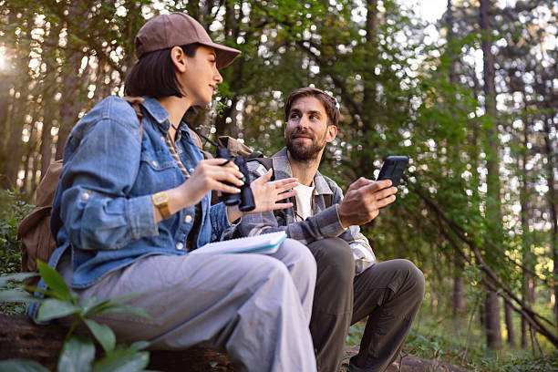 istock Two individuals enjoying birdwatching amidst a lush green forest environment 2214995059