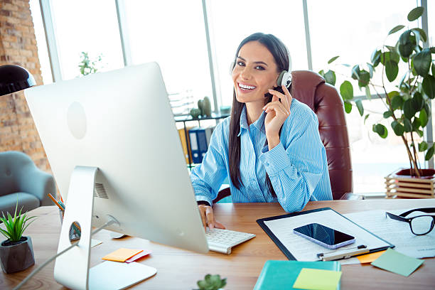 istock Confident businesswoman wearing headset providing support in a modern office space while smiling enthusiastically 2214995193