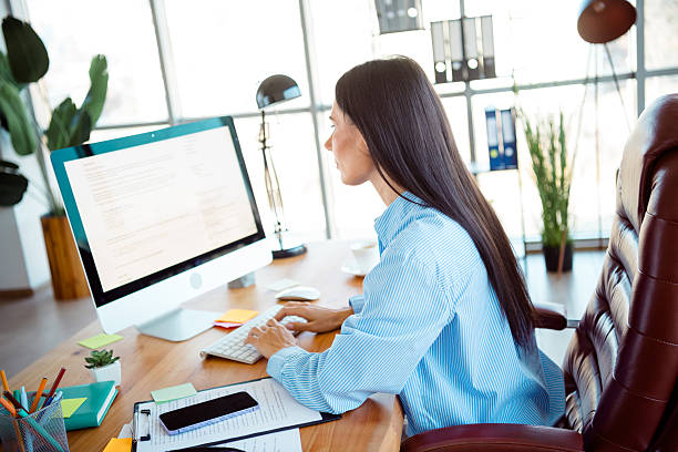 istock Professional woman working in a well-lit modern office environment, demonstrating dedication and focus on her tasks 2214995200