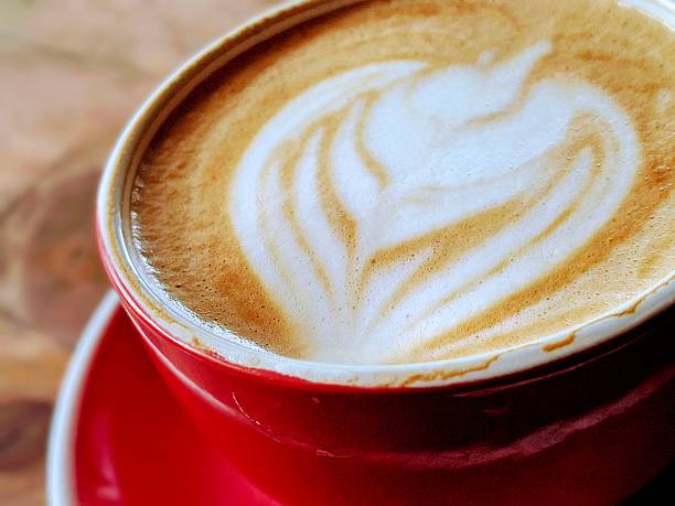 Close-Up of Latte Art in a Red Coffee Cup on a Wooden Table