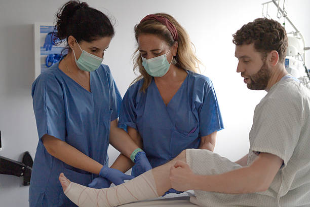 istock Nurses bandaging patient's leg in hospital room 2214995812