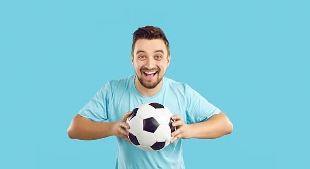 istock Overjoyed man with ball support football team 2214996224