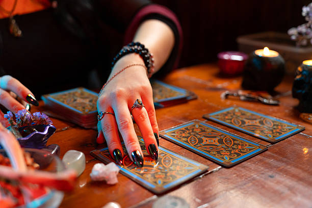 istock Fortune teller reading tarot cards predicting future on wooden table 2214997196