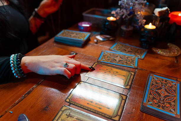 istock Fortune teller reading tarot cards on wooden table with candles 2214997491
