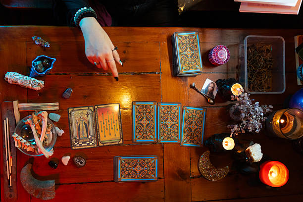 istock Fortune teller reading tarot cards on wooden table with candles 2214997610