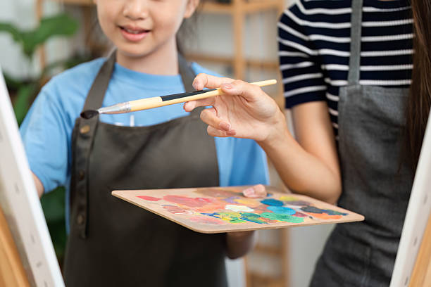 istock Creative bonding through art: Mother and daughter sharing paint colors 2214998974