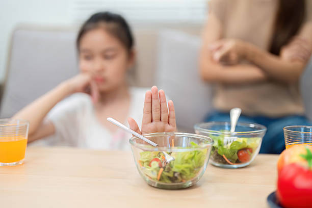 istock Wellness: Child refusing to eat healthy salad during mealtime 2214999078