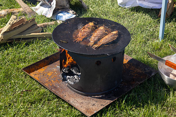 istock Grilled whole fish cooking on outdoor fire plate 2214999104