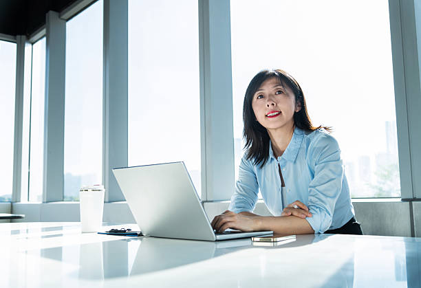 istock Businesswoman using laptop by the window 2215000115