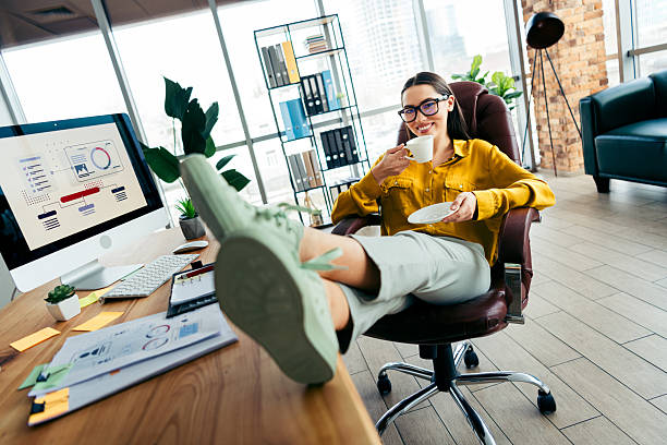 istock Young professional woman enjoying a coffee break in modern workplace while relaxing and maintaining a positive work life balance 2215000344