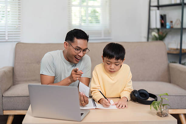 istock Homeschool father and son working on assignments together 2215000396