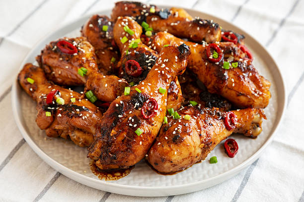 istock Homemade Easy Sticky Chicken Drumsticks on a Plate, low angle view. Close-up. 2215002815