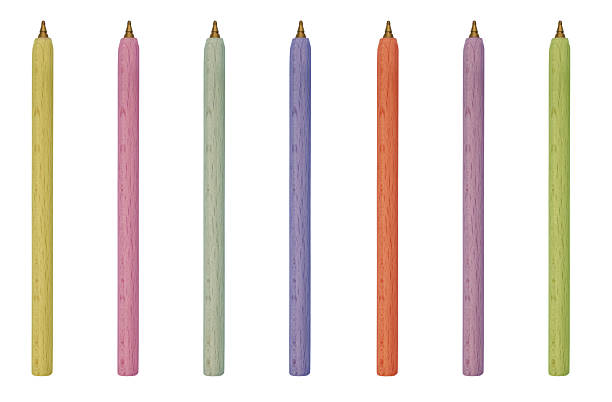 Five colorful markers with yellow bodies and different colored caps lined up on a light wooden desk, ideal for office, school, and creativity concepts.