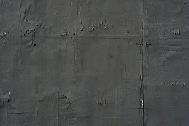 Old faded black wooden wall in bad condition.
