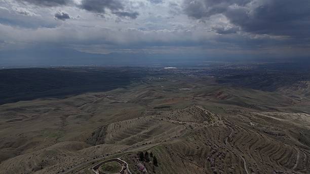 istock Aerial view of rolling hills sparse vegetation cloudy sky 2215003852
