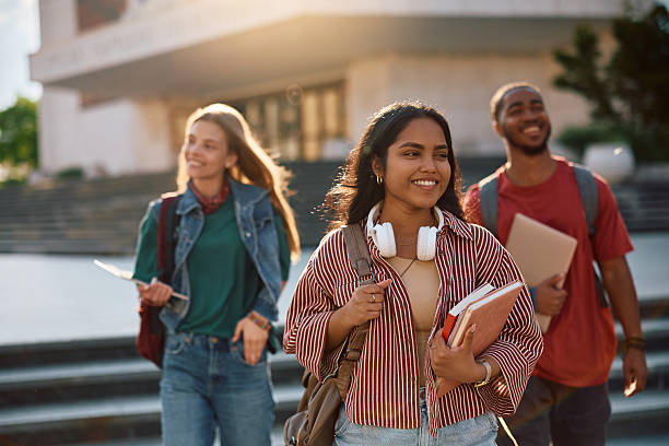 istock Happy Indian university student and her friends walking through campus. 2215003889