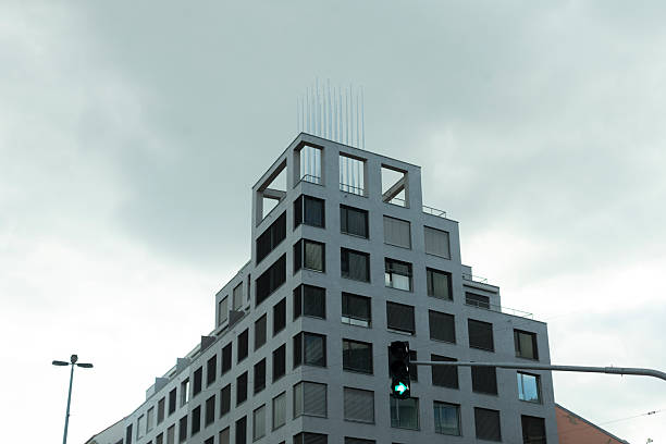 A modern contemporary building design set against a dramatic overcast sky, ideal for themes related to urban architecture