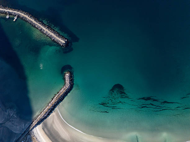 breakwater at the entrance of a harbor, turquoise sea. Aerial view with drone