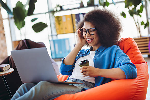 istock Charming young businesswoman working in a modern office space, enjoying a break while seated comfortably and smiling 2215004635