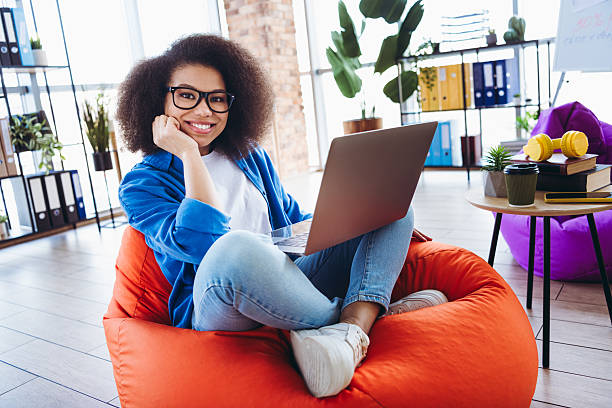 istock Young professional woman in modern workspace using a laptop in a casual and stylish setting with a vibrant atmosphere 2215004687