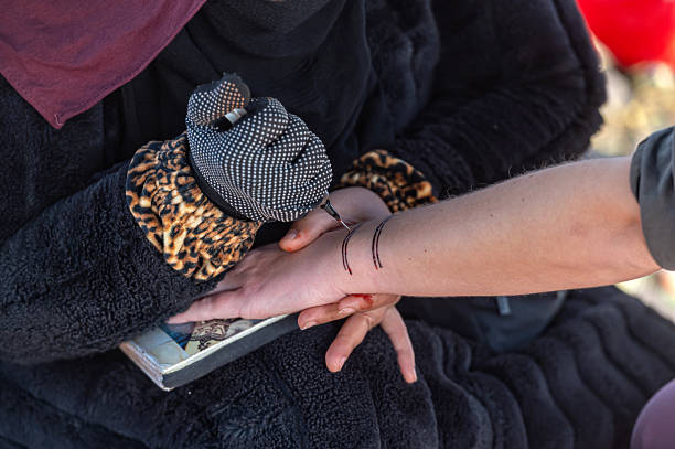 Skilled henna artist creates beautiful patterns on a client's hand in Marrakech.