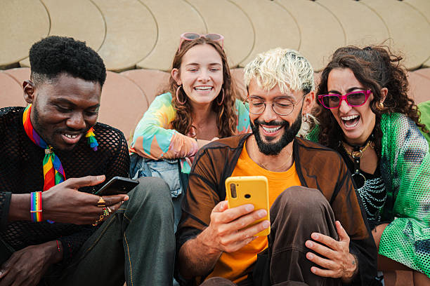 istock Young happy multiracial people having a good time while using a mobile phone to browse the internet and share photos on social media. A group of friends using apps on a cellphone to play online 2215006617