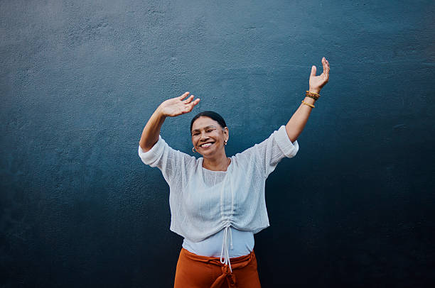 istock Joyful Woman Dancing Against Blue Wall 2215006712