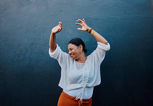 istock Joyful Woman Dancing Against Blue Wall 2215006717
