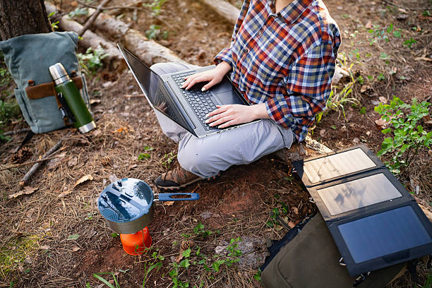 istock Person working on laptop outdoors with solar charger and camping setup 2215006858