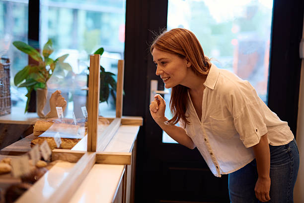 istock Young woman choosing fresh bread in a bakery shop window display 2215007241