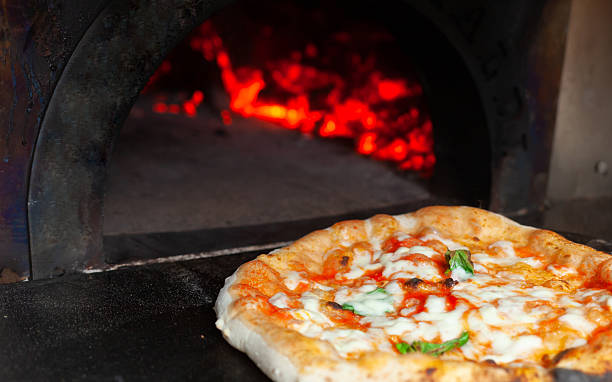 istock Delicious Neapolitan pizza baking in a wood-fired oven 2215009823