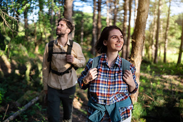 istock Young couple hiking through a forested path on a sunny day 2215012422