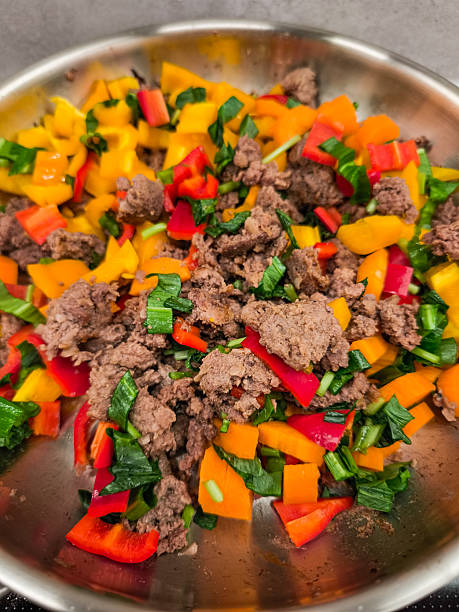 Ground meat cooking with chopped vegetables in a pan
