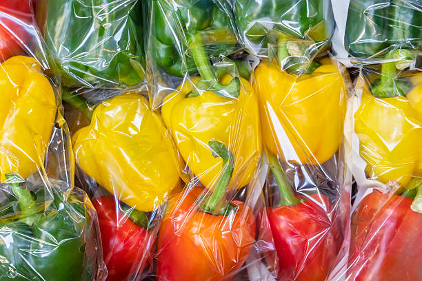 istock Plastic wrapped yellow, green and red bell peppers 2215015704