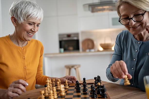 istock Two senior women playing chess at home, enjoying retirement 2215015886