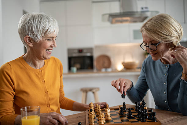 istock Two senior women playing chess and having fun at home 2215015887