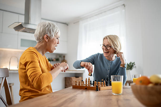 istock Two senior women playing chess and having fun at home 2215015929