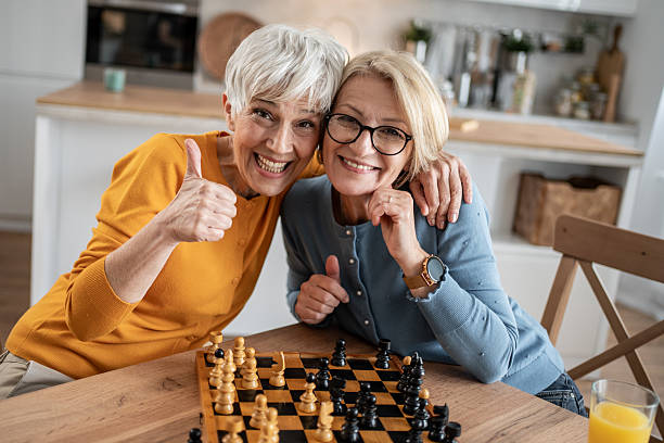 istock Two senior women playing chess and having fun at home 2215015987