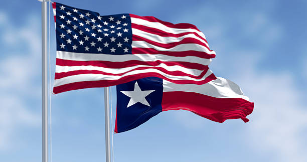 istock Texas and American flags waving together in blue sky. 3D render 2215021318