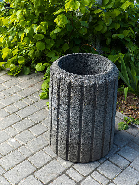 istock A large stone trash can sitting on a brick walkway 2215021838